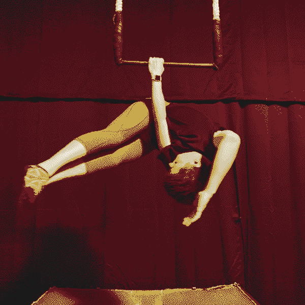 Luci in capri yoga pants, athletic t-shirt, and short socks practicing a 'meathook' on a dance trapeze.